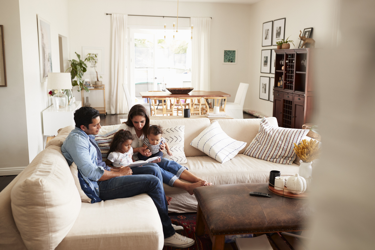 Parents spending time with their two children on the sofa at home